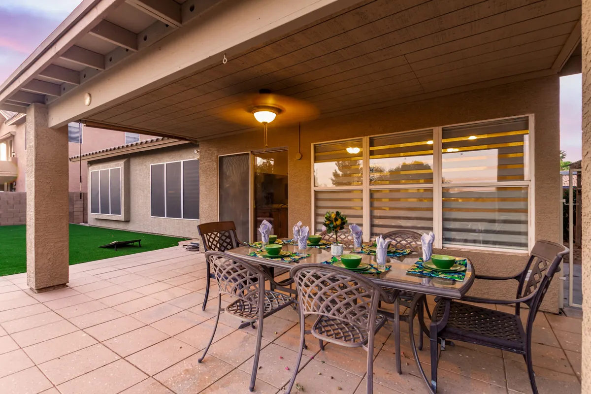 An exterior patio scene with a dining table, outdoor furniture, and a decorative centerpiece. The space exudes an inviting and cozy atmosphere, perfect for al fresco meals, entertaining, and group gatherings—echoing the social, communal spirit of the Heritage District.