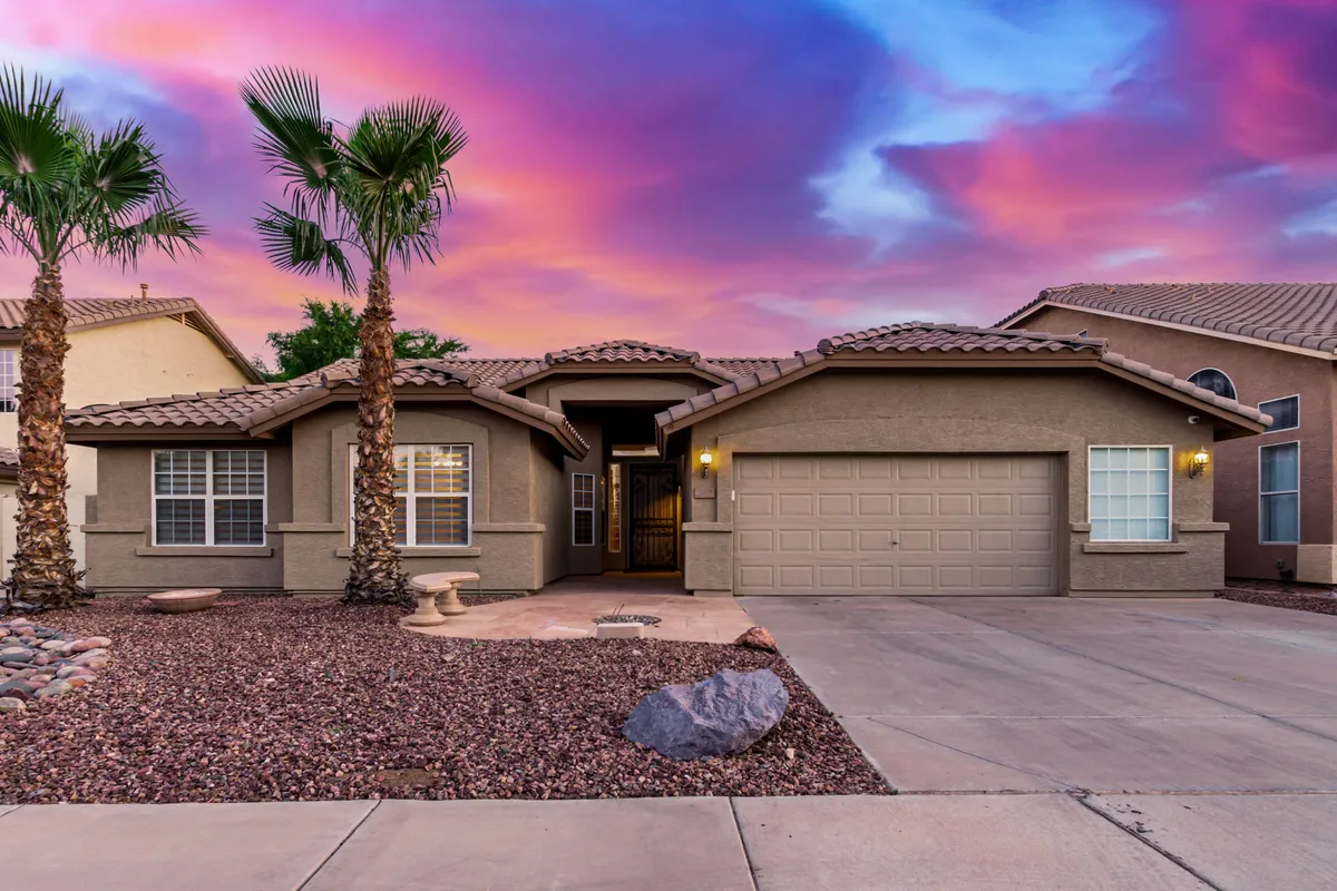 This image showcases the front entrance of the property, framed by swaying palm trees and a landscaped gravel area. The inviting exterior sets an upbeat, welcoming tone and subtly alludes to a vibrant neighborhood beyond. The mood is warm and hints at gathering loved ones before heading out to explore nearby attractions.
